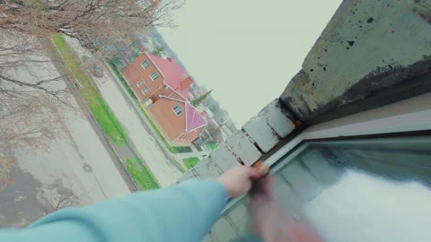 A man washes the glass of a plastic window outside the apartment with a sponge. Stock Footage 334129859