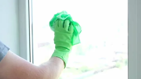 A man washes glass window and a plastic frame with a folk remedy with household Stock Footage 201316592