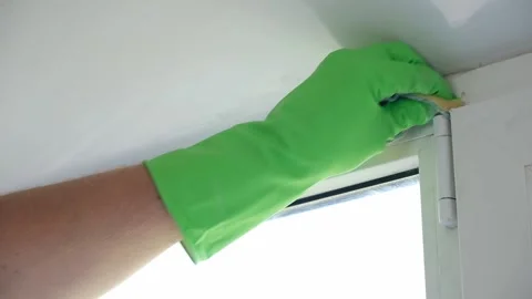 A man washes glass window and a plastic frame with a folk remedy with household Stock Footage 201630089