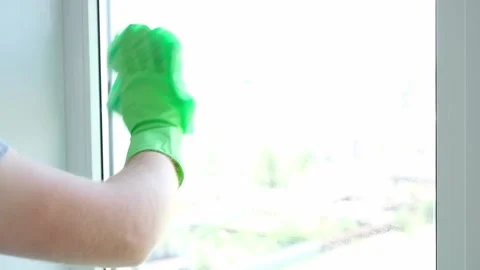 A man washes glass window and a plastic frame with a folk remedy with household Stock Footage 205941545