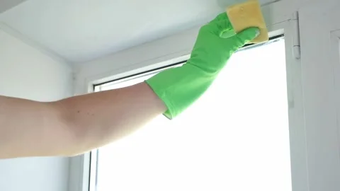 A man washes glass window and a plastic frame with a folk remedy with household Stock Footage 208484688