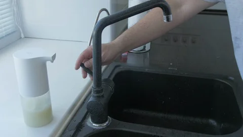 Man washes hands with soap in the kitchen with brush Stock Footage 129326345