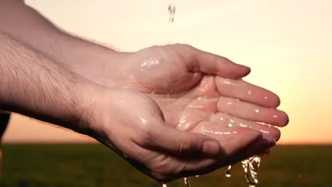 Man washes hands sunset, taking care hygiene cleanliness. people strive ensure Stock Footage 258988820