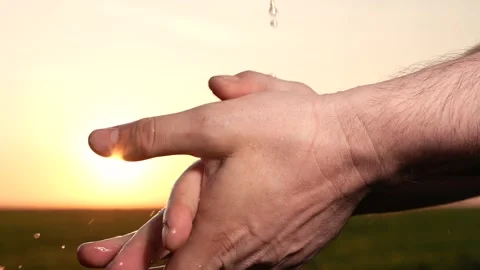 Man washes hands sunset, taking care hygiene cleanliness. people strive ensure Stock Footage 261500475