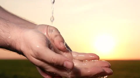 Man washes hands sunset, taking care hygiene cleanliness. people strive ensure Stock Footage 265478411