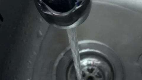 Man washes hands under running tap in stainless steel sink. Closeup from above Stock Footage 104782846
