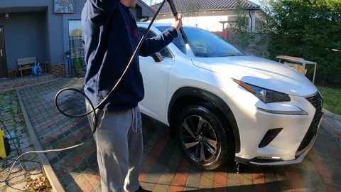A man washes his car in the yard Stock Footage 162676618