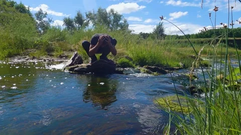 A man washes his face in the river. Slow motion Stock-Footage 199194755