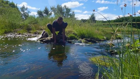 A man washes his face in the river. Slow motion Stock-Footage 199194806