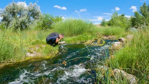 A man washes his face in the river. Slow motion 스톡 동영상 199194998