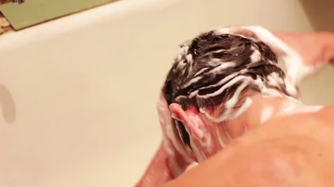 Man washes his hair Stock Footage