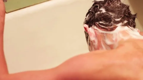 Man washes his hair Stock Footage