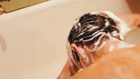 Man washes his hair Stock Footage