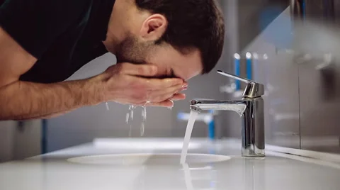 A man washes his hands and face Stock Footage 47897423