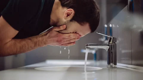 A man washes his hands and face Stock Footage 47897483