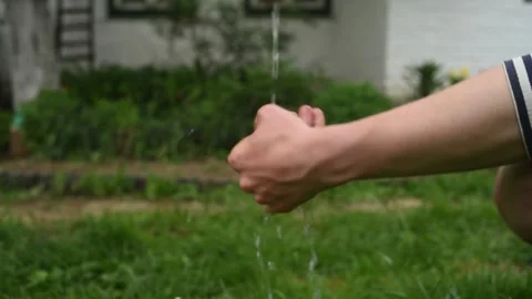 Man washes his hands on a background of green grass Stock Footage 131339666