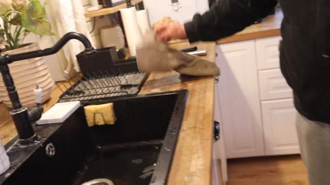 A man washes his hands in a black modern kitchen sink, side view Stock-Footage 274894975