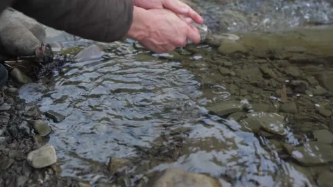 Man washes his hands in the clear river, beautiful man's hands Stock Footage 211816091