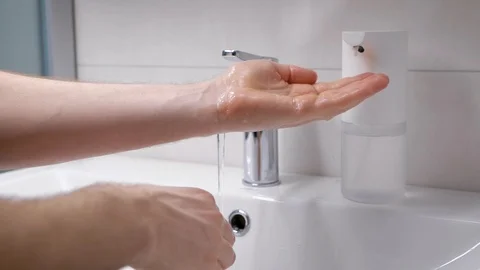 A man washes his hands in his bathroom. Men's hands in the frame, a modern house Stock Footage 128749512