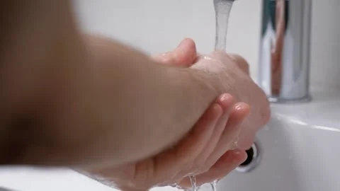 A man washes his hands in his bathroom. Men's hands in the frame, a modern house Stock Footage 130957452