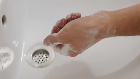 Man washes his hands with liquid soap in a bathroom Stock Footage 130780271