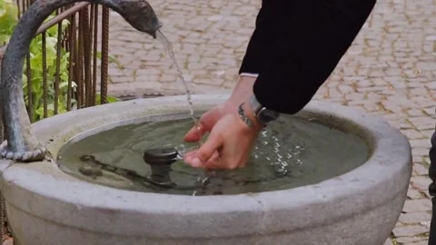 A man washes his hands at a public water faucet on the street Stock Footage 332710213