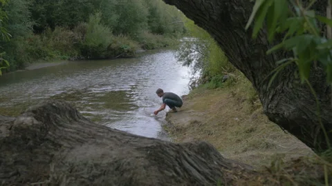 A man washes his hands in a river, in New Zealand Stock Footage 218386745