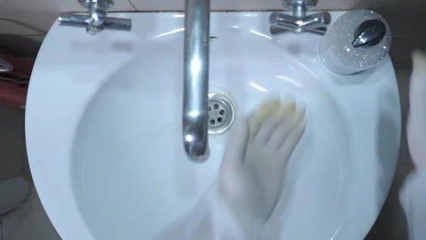 The man washes his hands with rubber gloves and liquid soap in the bathroom. Stock Footage 126726346