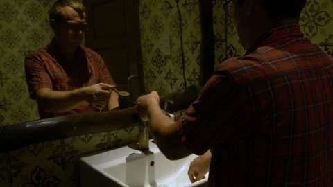 A man washes his hands in a sink and wipes himself with a towel Stock Footage 91452136
