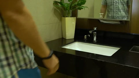 A man washes his hands in a sink and wipes them with napkins Stock Footage 92144178