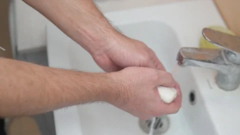 A man washes his hands with soap under water Stock Footage 128105287