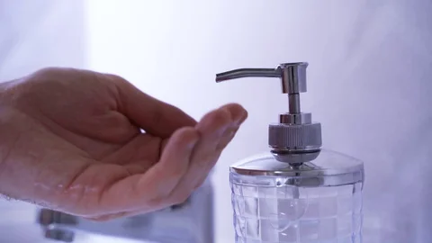 A man washes his hands with soap in a gray bathroom Stock Footage 130010422