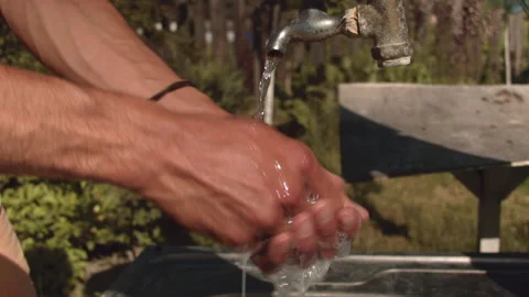 A man washes his hands in the summer on the street Vídeo Stock 132734165