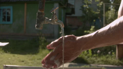 A man washes his hands in the summer on the street 스톡 동영상 132734445
