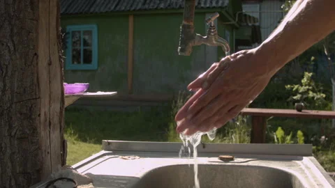 A man washes his hands in the summer on the street 스톡 동영상 132739130