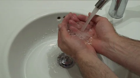 Man washes his hands under water tap Stock Footage 117922170