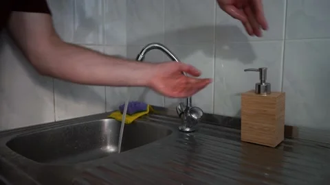 Man washes his hands under the tap in the kitchen Stock Footage 163163754