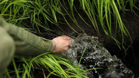 Man washes his hands in a wild creek 库存影片 93542222