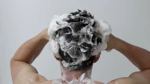 A man washes his head with shampoo on white background, rear view Vidéo 137295490