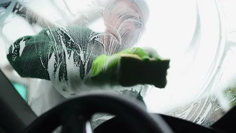 Man washes his windshield with a yellow sponge with foam.frame inside the car Vidéo 164949119