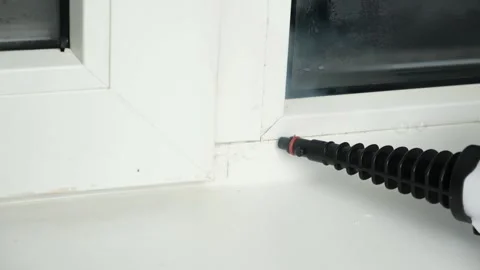 A man washes the joints on window with a steam cleaner. Steam cleaner for Stock-Footage 172079486