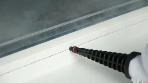 A man washes the joints on window with a steam cleaner. Steam cleaner for Stock-Footage 172325856