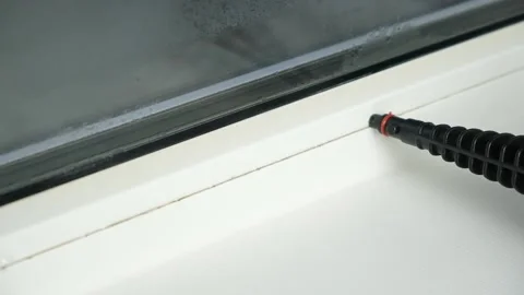 A man washes the joints on window with a steam cleaner. Steam cleaner for Stock-Footage 172552613