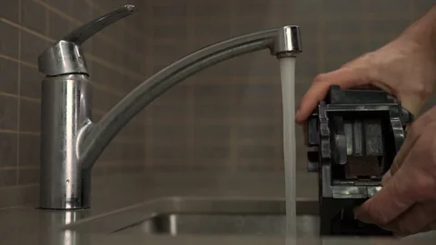 Man washes plastic coffee maker block under water jet Video stock 119017504