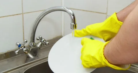 Man washes a plate Stock Footage 235512587