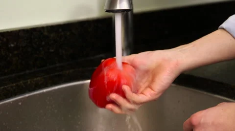 Man washes red bell pepper in sink Stock Footage 61394664