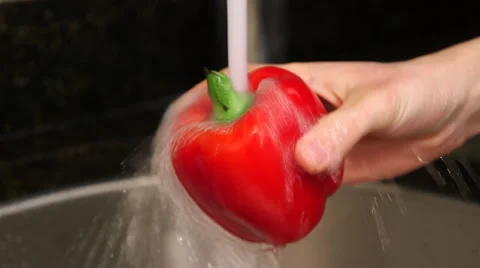 Man washes red bell pepper in sink close up Stock Footage 61394685