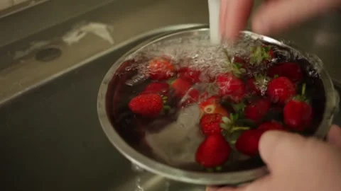 A man washes red berries under a stream of water. Fresh beautiful fruit Stock Footage 142992041