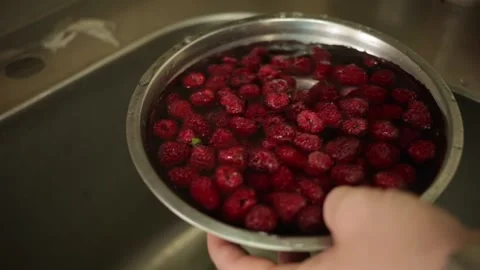 A man washes red berries under a stream of water. Fresh beautiful fruit Video stock 142992086