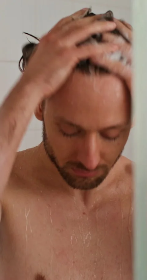 A man washes in the shower 스톡 동영상 287822377